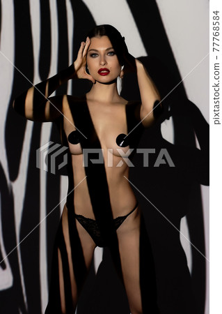 Fashion portrait of young lady with shadow on her body Fashion portrait of young lady with shadow on her body 77768584