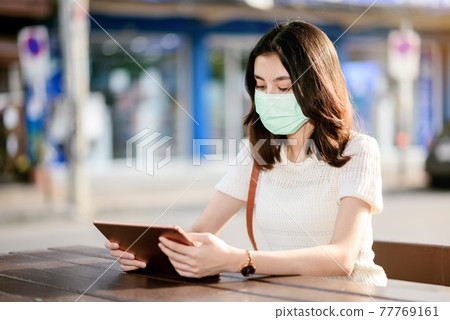 young beautiful asian woman showing how to wear a medical mask step by step on white background 77769161