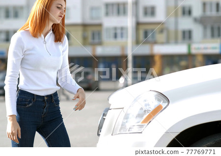 Young stressed woman driver near broken car having a prbreakdown problem with her vehicle waiting for assistance. Young stressed woman driver near broken car having a prbreakdown problem with her vehicle waiting for assistance. 77769771