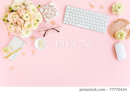 Stylized, pink women's home office desk. Workspace with computer, bouquet ranunculus and roses, clipboard on pink background. Flat lay. Top view. Stylized, pink women's home office desk. Workspace with computer, bouquet ranunculus and roses, clipboard on pink background. Flat lay. Top view. 77770434