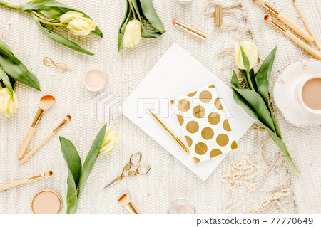 Female workspace with yellow tulip flowers, women's fashion golden accessories, diary, glasses on white background. Flat lay. Top view feminine. 77770649