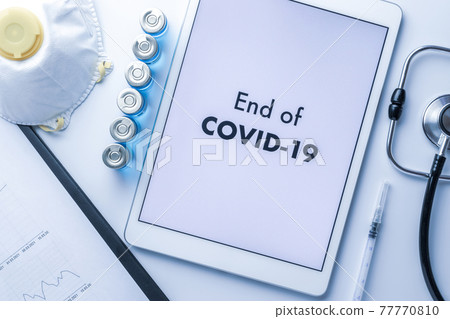 End of pandemic. Syringe with needle, hospital healthcare charts, doctor stethoscope and white tablet with text on screen for medical equipment background. End of COVID concept. End of pandemic. Syringe with needle, hospital healthcare charts, doctor stethoscope and white tablet with text on screen for medical equipment background. End of COVID concept. 77770810
