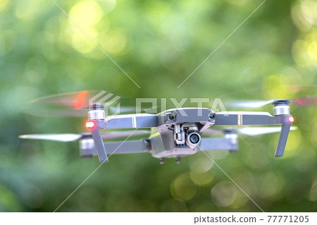 Drone aircraft with blurred fast rotating propellers and video camera flying in air. Drone aircraft with blurred fast rotating propellers and video camera flying in air. 77771205