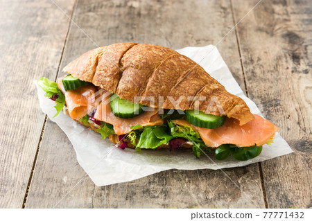 Croissant sandwich with salmon and vegetables 77771432