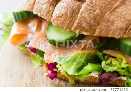 Croissant sandwich with salmon and vegetables 77771433