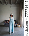 Woman in VR glasses experiencing virtual reality at home 77771647