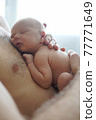Crop unrecognizable father embracing sleeping baby 77771649
