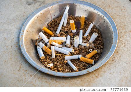cigarette butt ashtray Close up of cigarettes butts in metal ashtray... - Stock Photo [77771689]