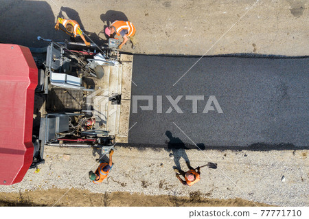 Aerial view of new road construction with asphalt laying machinery at work. 77771710