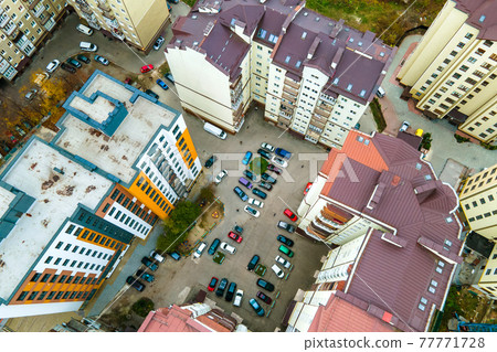 Aerial view of parked cars on parking lot between high apartment buildings. Aerial view of parked cars on parking lot between high apartment buildings. 77771728