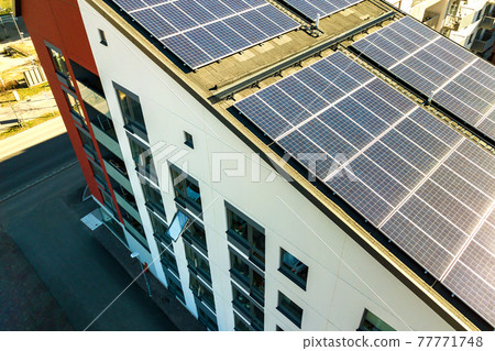 Aerial view of solar photovoltaic panels on a roof top of residential building block for producing clean electric energy. Autonomous housing concept. 77771748