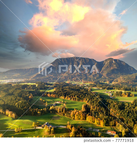 Aerial view of green meadows with villages and forest in austrian Alps mountains. 77771918