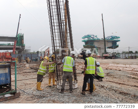 KUALA LUMPUR, MALAYSIA -JANUARY 18, 2017: Construction workers fabricating steel reinforcement bar at the construction site in Kuala Lumpur, Malaysia. The reinforcement bar was tied together using tin KUALA LUMPUR, MALAYSIA -JANUARY 18, 2017: Construction workers fabricating steel reinforcement bar at the construction site in Kuala Lumpur, Malaysia. The reinforcement bar was tied together using tin 77772339