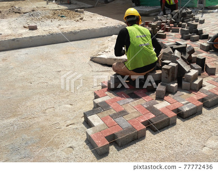 MALACCA, MALAYSIA -MAC 08, 2017: Construction workers installing and arranging precast concrete pavers stone for the road at the construction site.  77772436