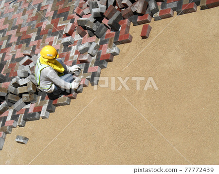 MALACCA, MALAYSIA -MAC 08, 2017: Construction workers installing and arranging precast concrete pavers stone for the road at the construction site.  77772439
