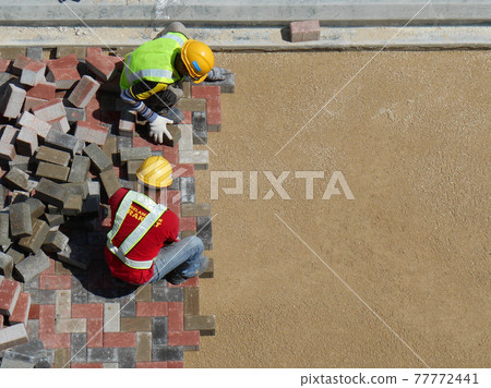 MALACCA, MALAYSIA -MAC 08, 2017: Construction workers installing and arranging precast concrete pavers stone for the road at the construction site.  77772441