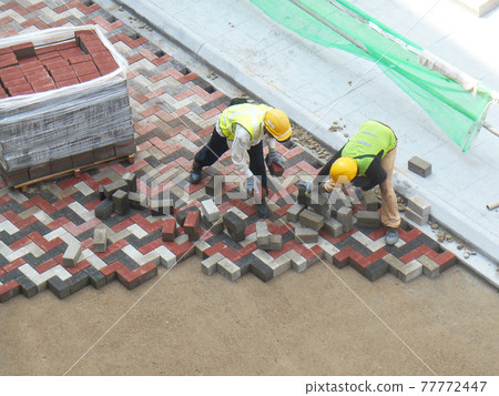 MALACCA, MALAYSIA -MAC 08, 2017: Construction workers installing and arranging precast concrete pavers stone for the road at the construction site. MALACCA, MALAYSIA -MAC 08, 2017: Construction workers installing and arranging precast concrete pavers stone for the road at the construction site. 77772447