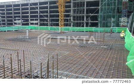 JOHOR, MALAYSIA -MARCH 18, 2017: Steel reinforcement bar at the construction site. It uses to strengthen concrete to form reinforced concrete. It is tied together by workers using tiny wire.  77772463