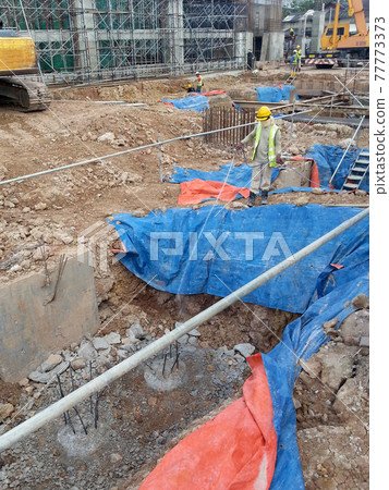 JOHOR, MALAYSIA -MARCH 29, 2016: Construction workers spraying the anti termite chemical treatment to the soil at the construction site. JOHOR, MALAYSIA -MARCH 29, 2016: Construction workers spraying the anti termite chemical treatment to the soil at the construction site. 77773373