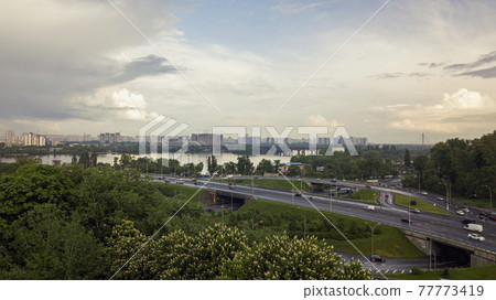 Bird's-eye view of the road and river. summer blooming chestnut Ukraine, Kiev May 18, 2021 Bird's-eye view of the road and river. summer blooming chestnut Ukraine, Kiev May 18, 2021 77773419