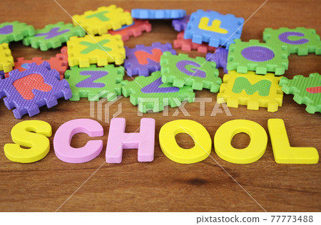 SCHOOL conceptual word made from rubber foam and colorful rubber puzzle alphabet randomly arrange. Isolated on wood texture background. SCHOOL conceptual word made from rubber foam and colorful rubber puzzle alphabet randomly arrange. Isolated on wood texture background. 77773488