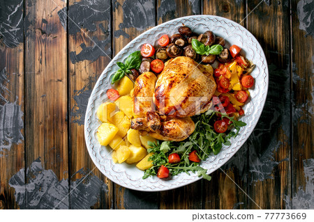 Grilled cooked whole chicken with grilled bell pepper and potatoes 77773669