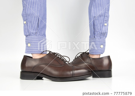 Classic brown shoes worn on the hands on a white background 77775879