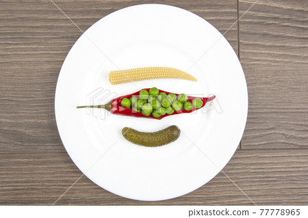salad of pickled and pickled corn, peas, cucumber and red pepper on a white plate. salad of pickled and pickled corn, peas, cucumber and red pepper on a white plate. 77778965