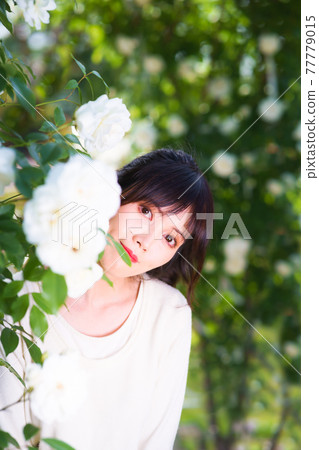 一個可愛的女孩從白玫瑰拱門中飄出 一個可愛的女孩從白玫瑰拱門中飄出 77779015