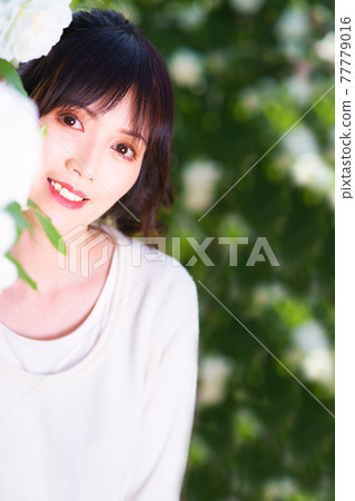 一個可愛的女孩從白玫瑰拱門中飄出 一個可愛的女孩從白玫瑰拱門中飄出 77779016
