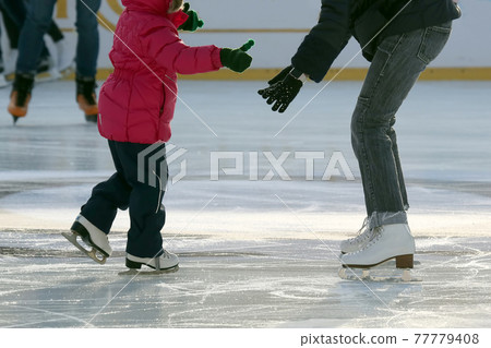 little girl with mother skate on the rink. little girl with mother skate on the rink. 77779408