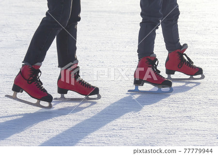 different people are actively skating on an ice rink. hobbies and leisure. winter sports 77779944