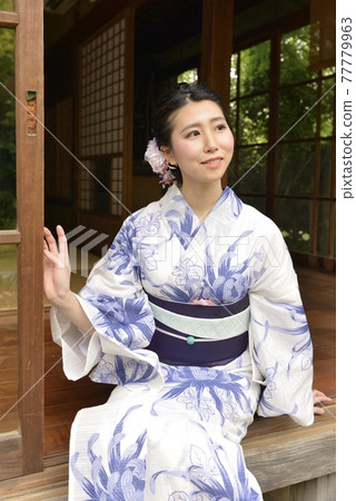A beautiful yukata woman sitting on the porch of an old folk house and smiling A beautiful yukata woman sitting on the porch of an old folk house and smiling 77779963