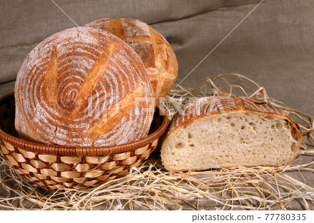 white bread lay in a straw basket on gray linen tablecloth white bread lay in a straw basket on gray linen tablecloth 77780335