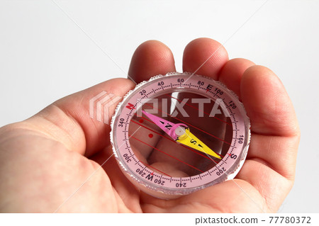 compass in the hand on white background compass in the hand on white background 77780372