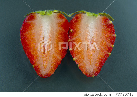 half of a strawberry on a green background half of a strawberry on a green background 77780713