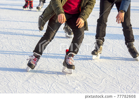 people ice skating on an ice rink. hobbies and leisure. winter sports people ice skating on an ice rink. hobbies and leisure. winter sports 77782608