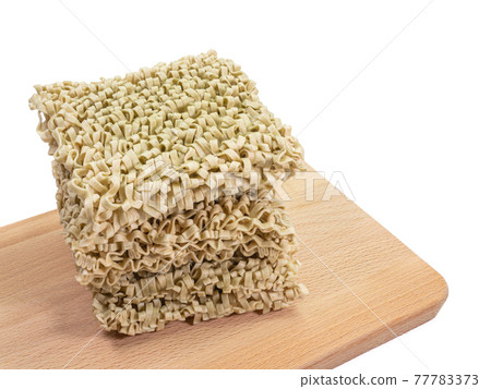 Spinach noodle, a close up of Taiwanese dried noodles fast food on wooden board isolated on white background. 77783373