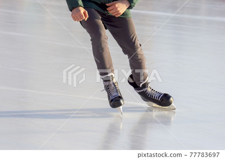 man actively skates on an ice rink. Hobbies and sports. Vacations and winter activities. man actively skates on an ice rink. Hobbies and sports. Vacations and winter activities. 77783697