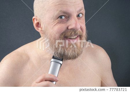 man with trimmer to adjust beard in hand. grooming and fashionable style barbershop 77783721