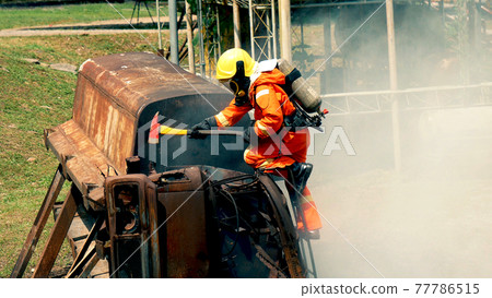 Firefighter fighting with flame using fire hose chemical water foam spray engine. Fireman wear hard hat, body safe suit uniform for protection. Rescue training in fire fighting extinguisher Firefighter fighting with flame using fire hose chemical water foam spray engine. Fireman wear hard hat, body safe suit uniform for protection. Rescue training in fire fighting extinguisher 77786515