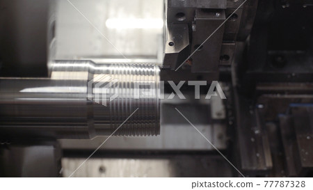 Turning lathe in action. Facing operation of metal blank on turning machine with cutting tool. Old turning lathe machine in turning workshop. Machining high precision mold part by cnc 77787328