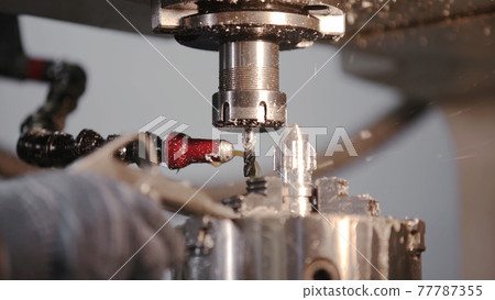 Produces metal detail in factory. Machine tools for metal working. A metal workpiece is machined by an electric machine. Cutting metal modern processing technology. Coolant and lubrication. Produces metal detail in factory. Machine tools for metal working. A metal workpiece is machined by an electric machine. Cutting metal modern processing technology. Coolant and lubrication. 77787355
