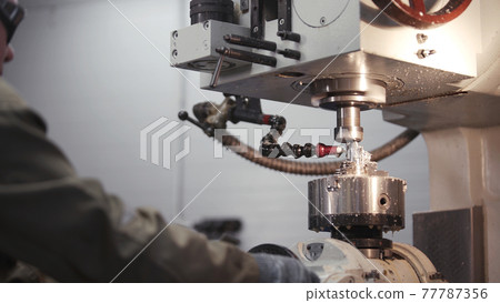 A metal workpiece is machined by an electric machine. Cutting metal modern processing technology. Coolant and lubrication. Produces metal detail in factory. Machine tools for metal working. 77787356