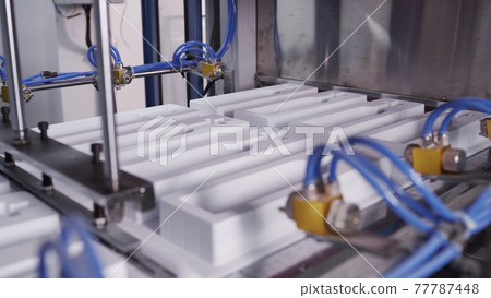 Machines create packing for bottles. Process of manufacturing plastic containers on extrusion equipment-moving mold. Work on high performance and precision machinery Machines create packing for bottles. Process of manufacturing plastic containers on extrusion equipment-moving mold. Work on high performance and precision machinery 77787448