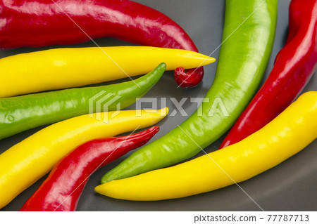 yellow, red and green hot chili on a plate. Pepper. Vegetable vitamin food. yellow, red and green hot chili on a plate. Pepper. Vegetable vitamin food. 77787713