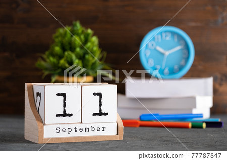 September 11th. September 11 wooden cube calendar with blur objects on background. September 11th. September 11 wooden cube calendar with blur objects on background. 77787847
