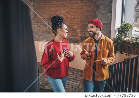 Young man and a woman talking and looking interested 77788756