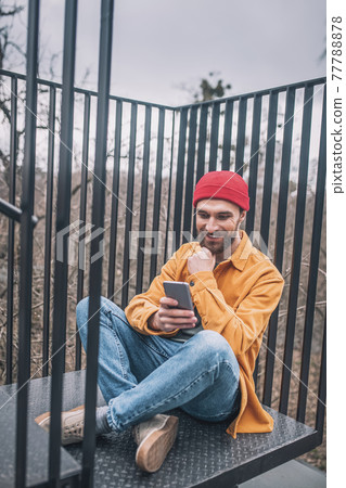 Man sitting on the steps of the city bridge 77788878