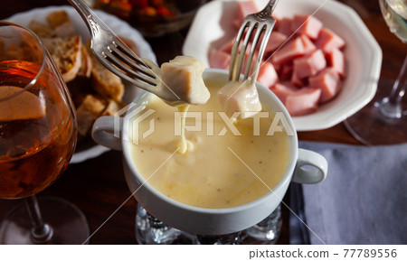 Cheese fondue with bread and snacks 77789556